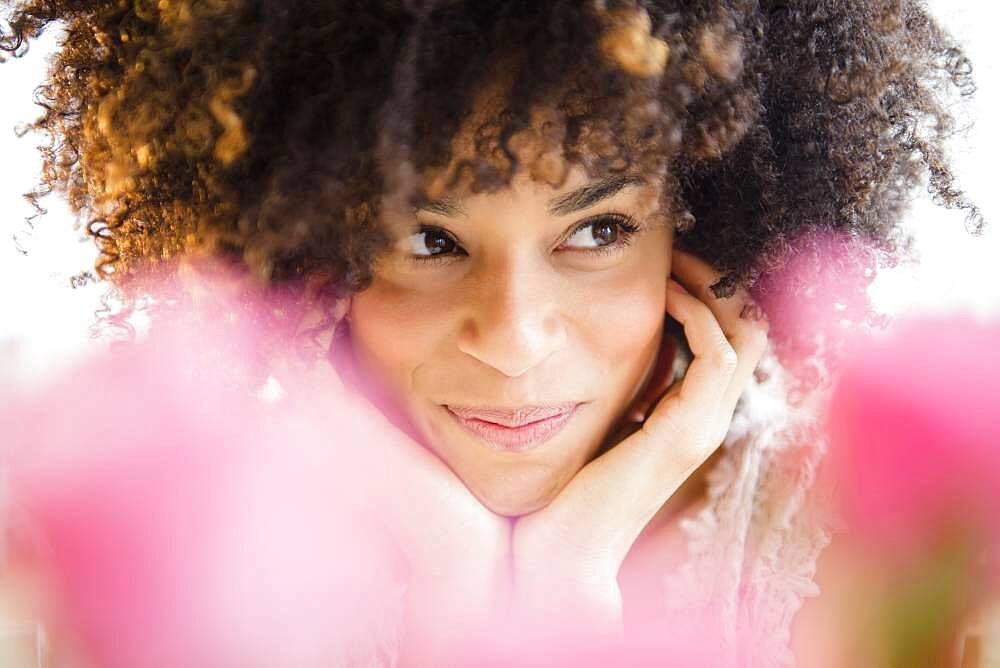 Mixed race woman resting chin in hands