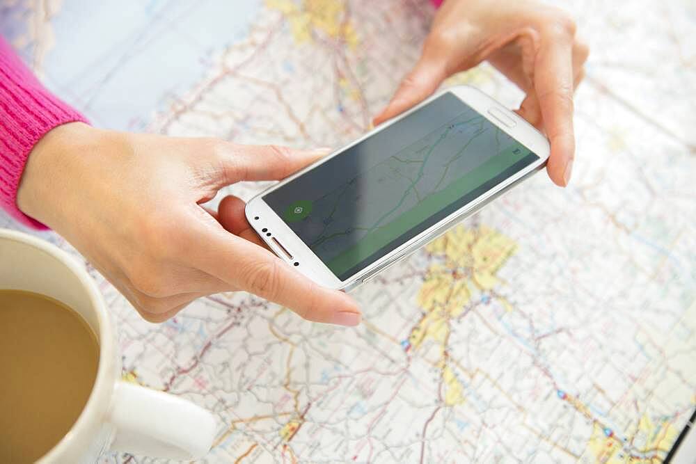 Mixed race woman taking cell phone photograph of roadmap