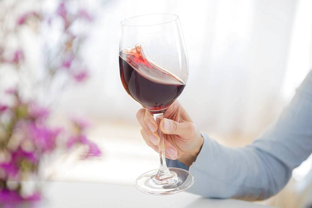 Mixed race woman swirling glass of wine