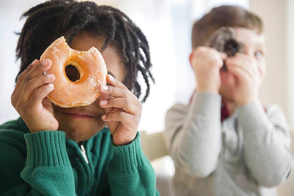 Boys peering through donut holes