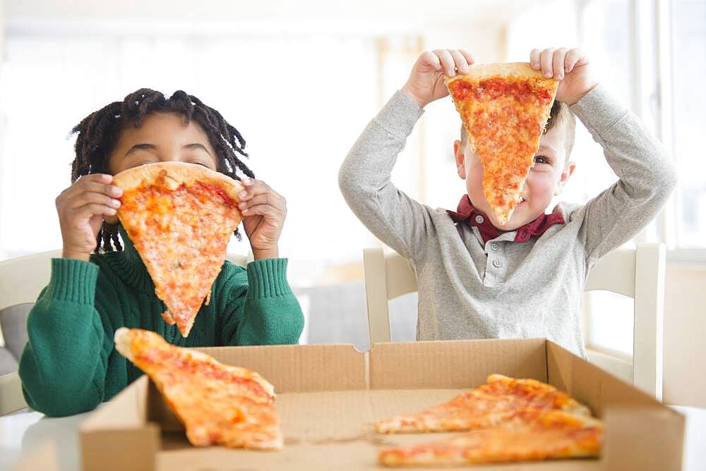 Boys eating pizza from cardboard box