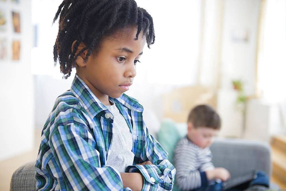 Boy ignoring friend in living room