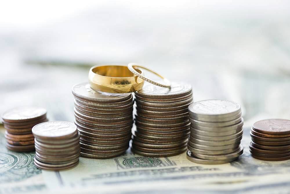 Close up of stacks of coins and wedding rings