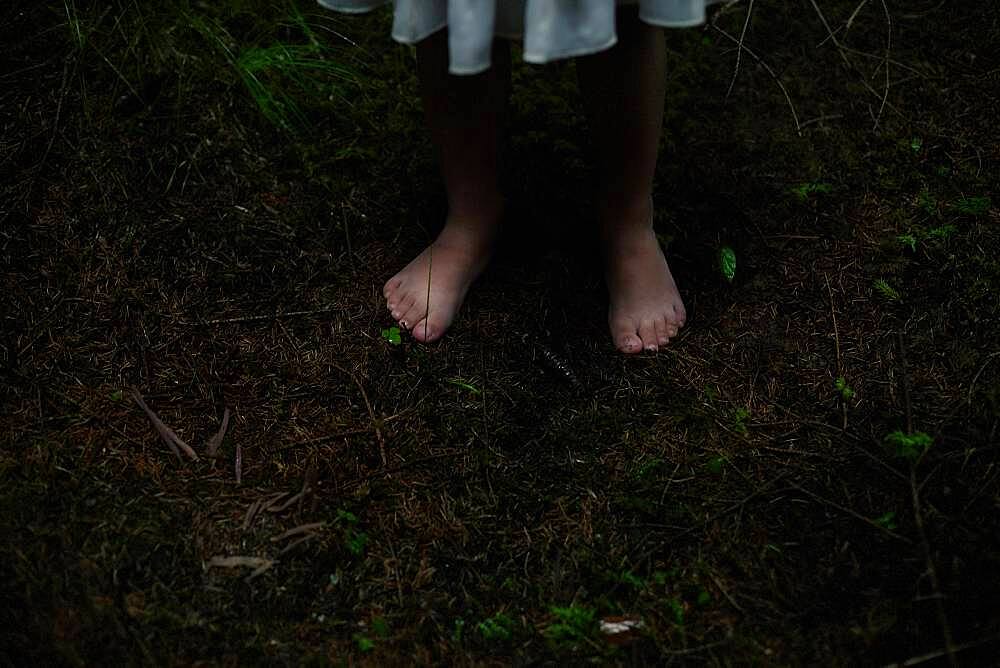 Caucasian girl with bare feet in dirt