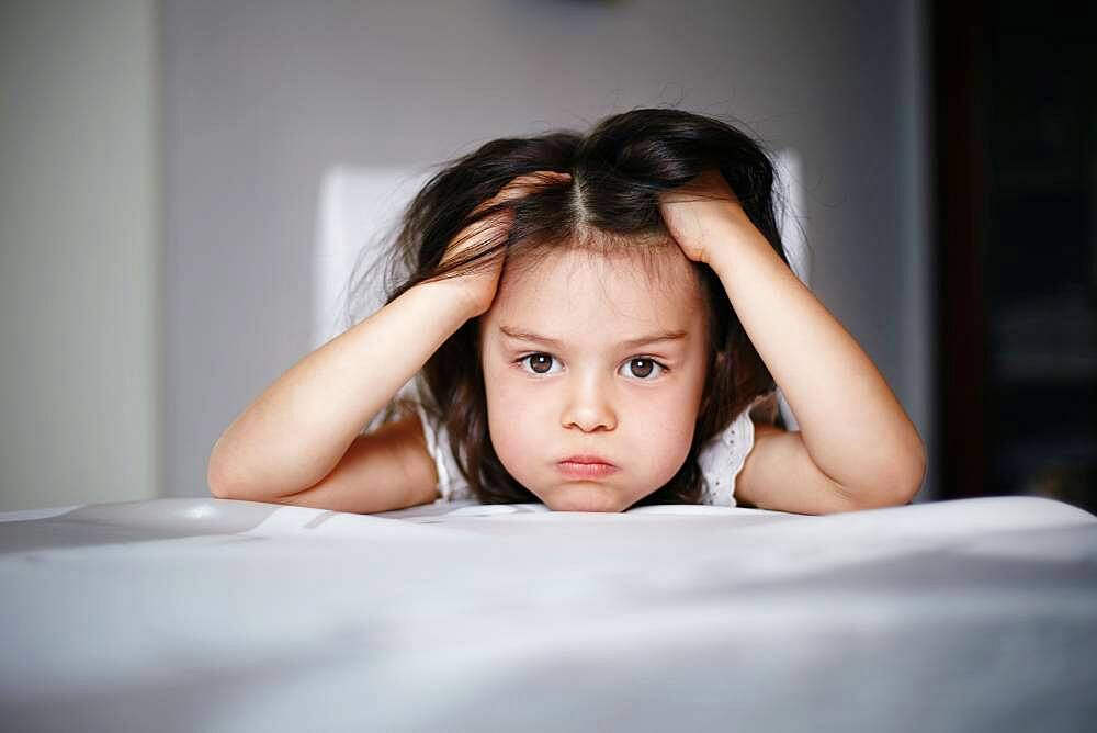 Frustrated Caucasian girl laying on bed