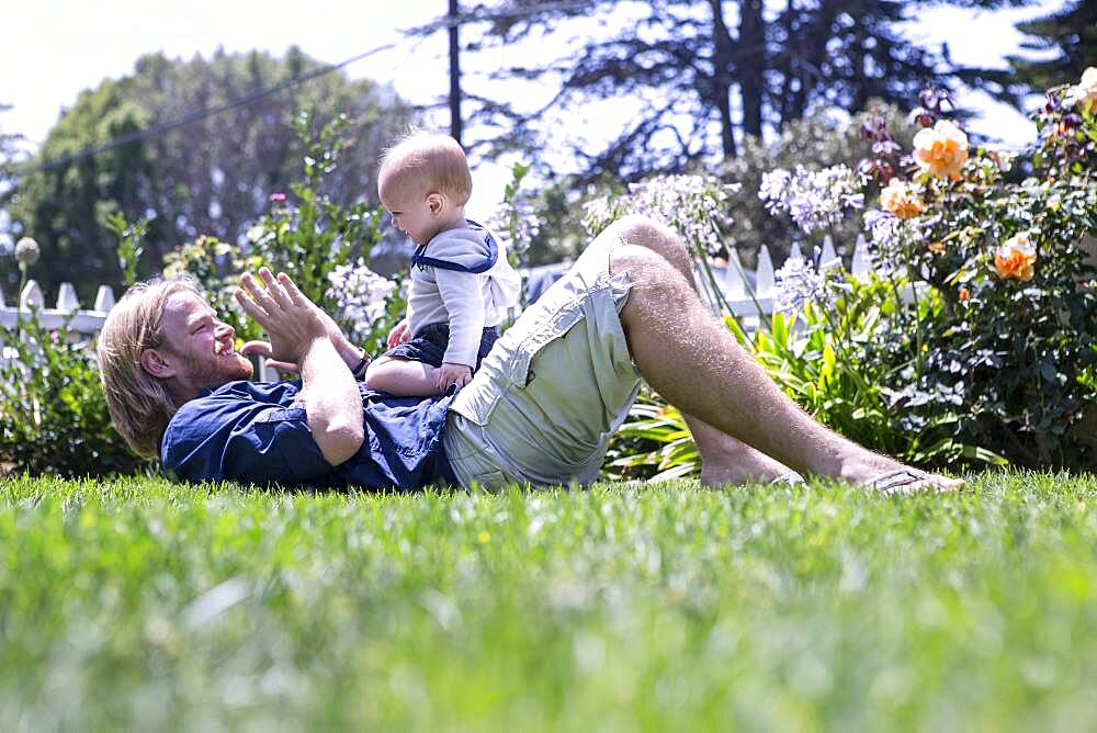 Caucasian father and son playing in grass