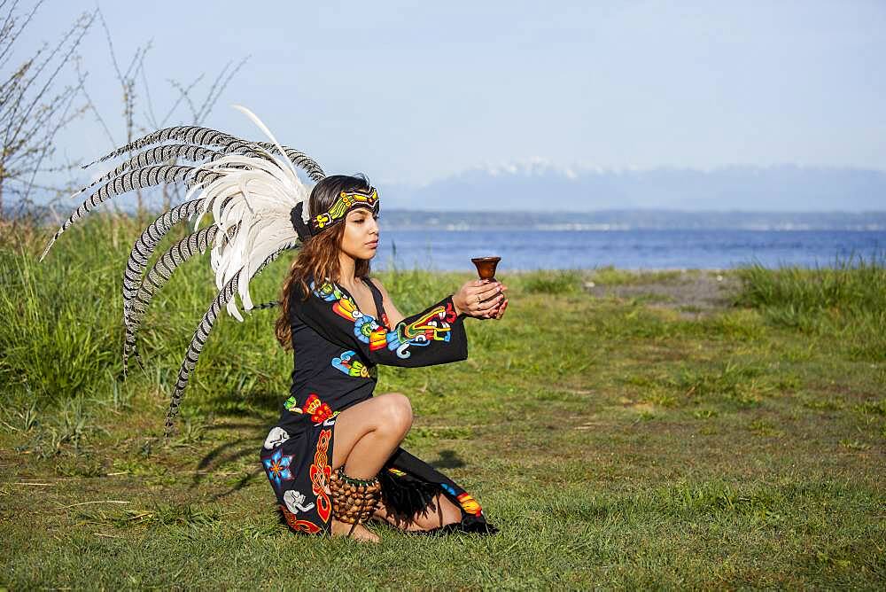 Native American woman in traditional headdress performing ceremony