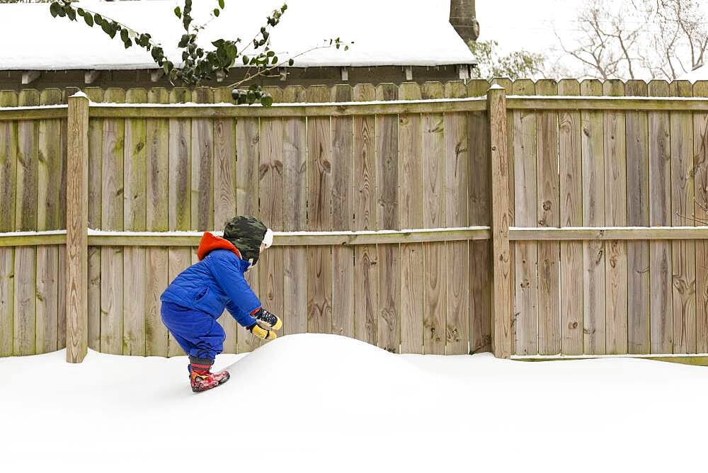 Caucasian boy playing in snow