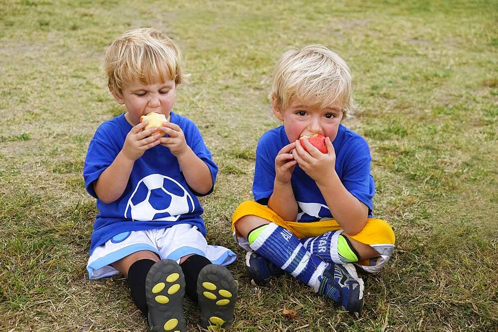 Caucasian soccer players eating apples