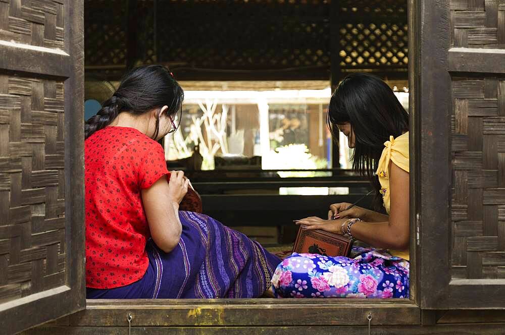 Asian artisans carving traditional design in workshop