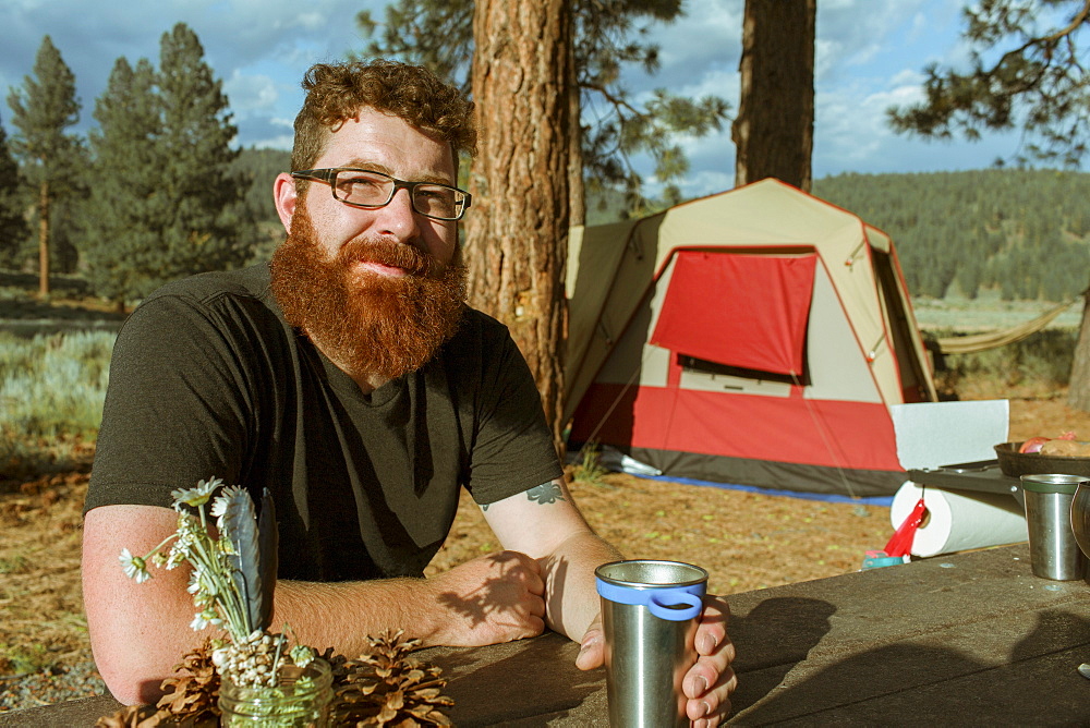 Caucasian man drinking at campsite