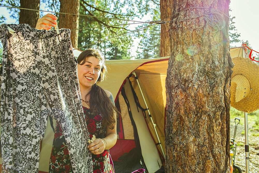 Caucasian woman hanging laundry at campsite