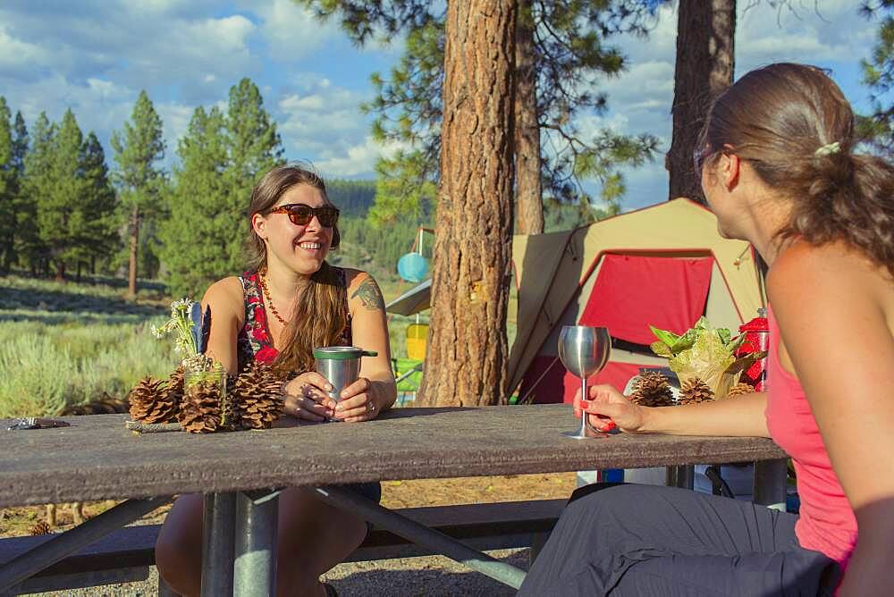 Caucasian women drinking wine at campsite