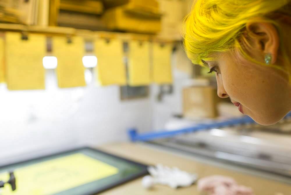 Caucasian artist working in screen print workshop