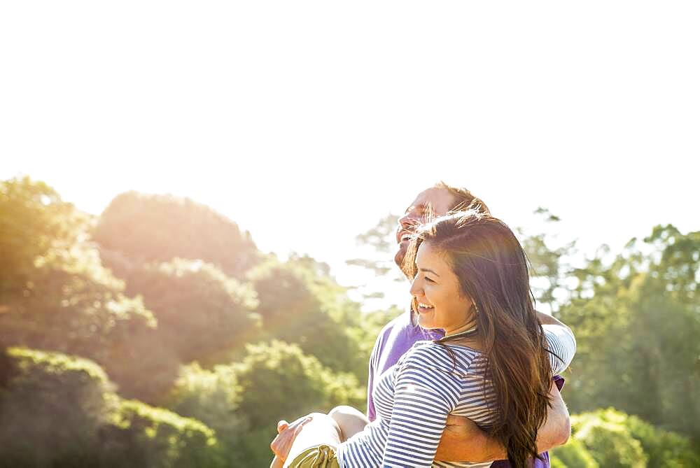 Man carrying girlfriend outdoors