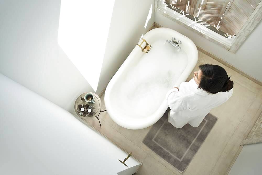 Woman having bubble bath in bathroom