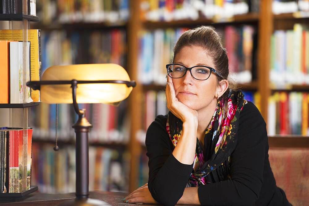 Librarian sitting at desk in library