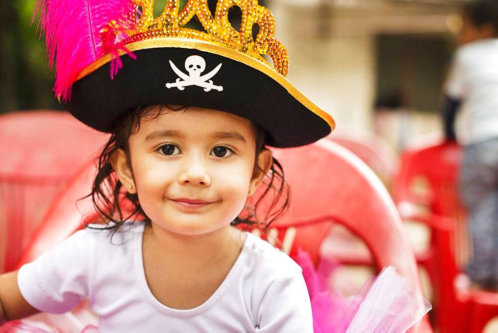 Hispanic girl wearing pirate hat at party