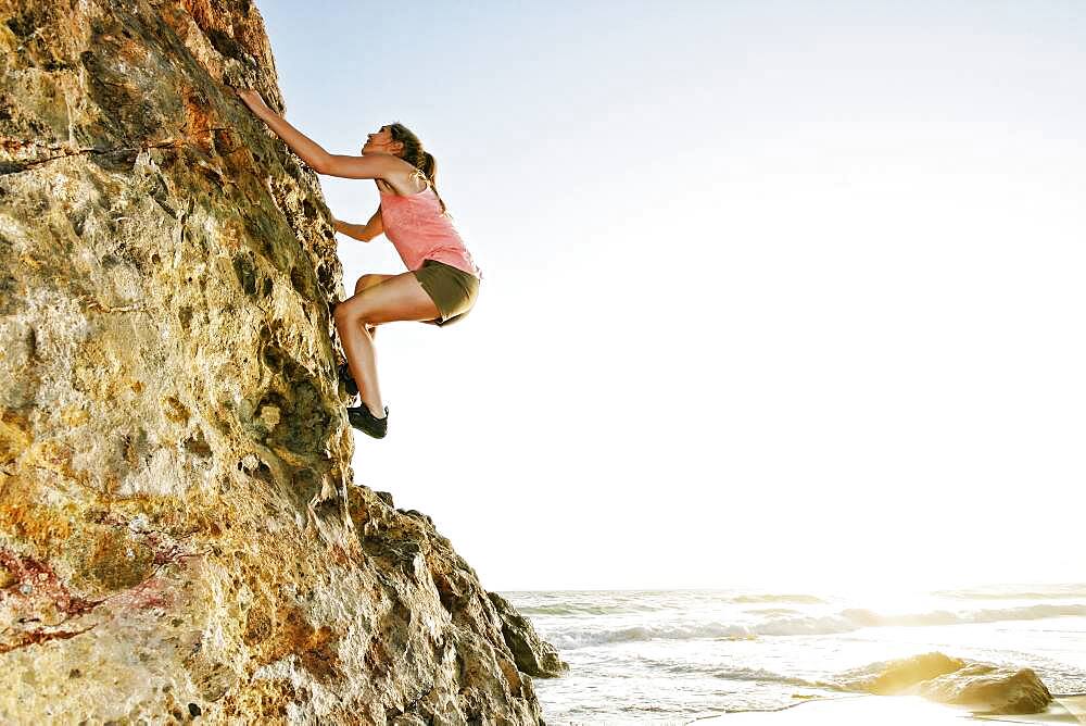 Woman climbing rock formation