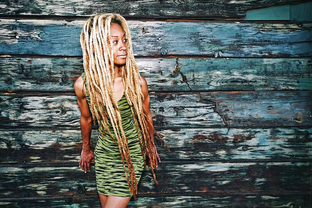 Black woman standing at wooden wall