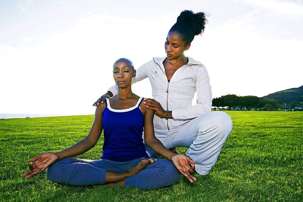 Woman practicing yoga with teacher in park