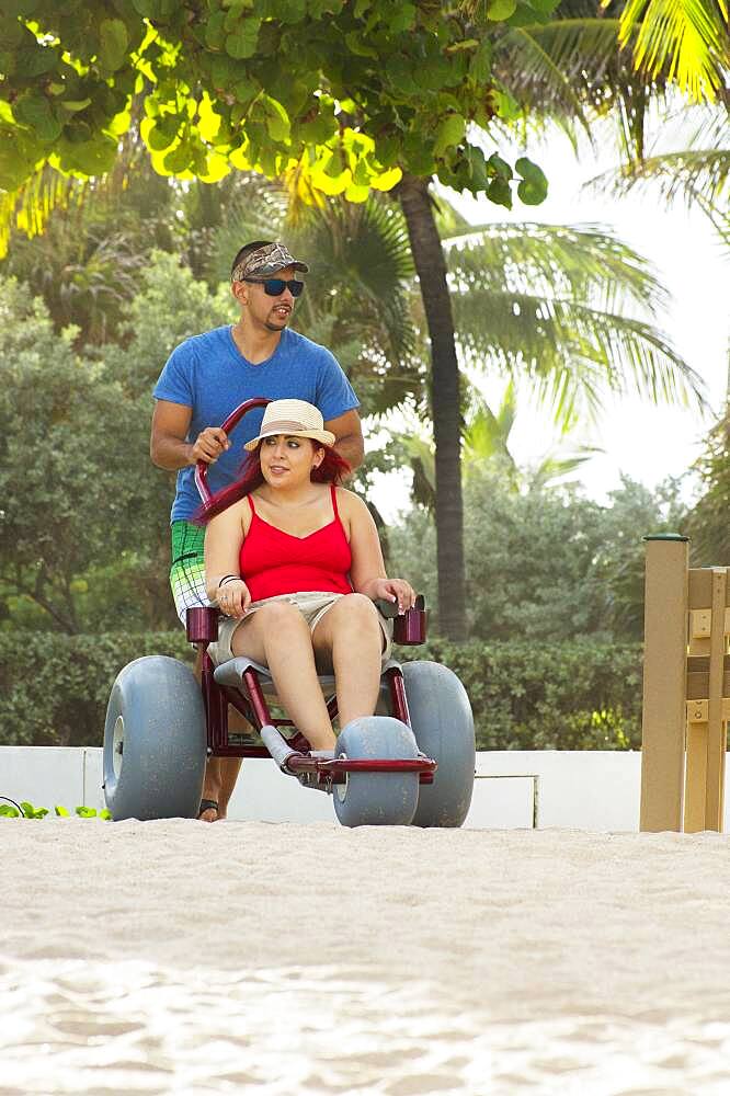 Man pushing paraplegic girlfriend in wheelchair