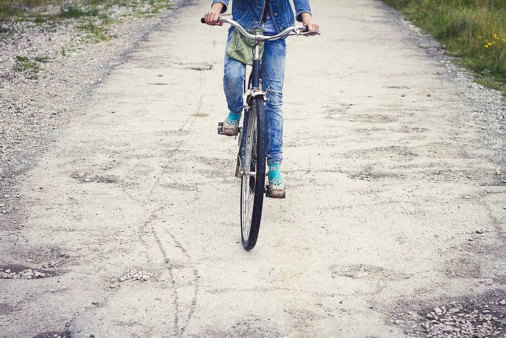 Caucasian teenage girl riding bicycle