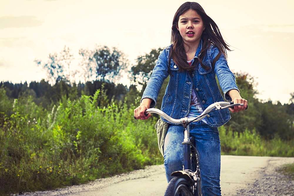 Caucasian teenage girl riding bicycle