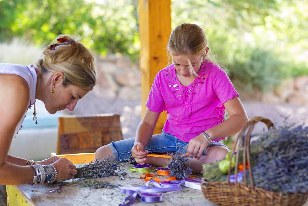 Caucasian mother and daughter making dried flower bundles