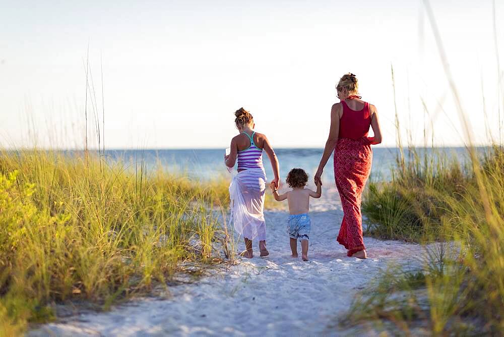 Caucasian mother and children walking on beach