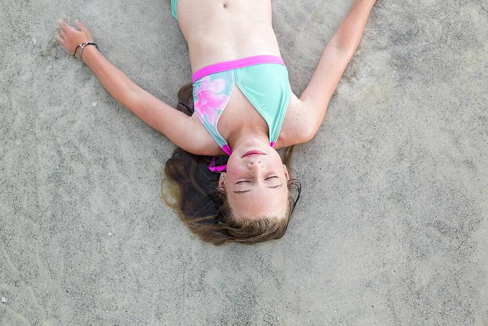 Caucasian girl napping on beach