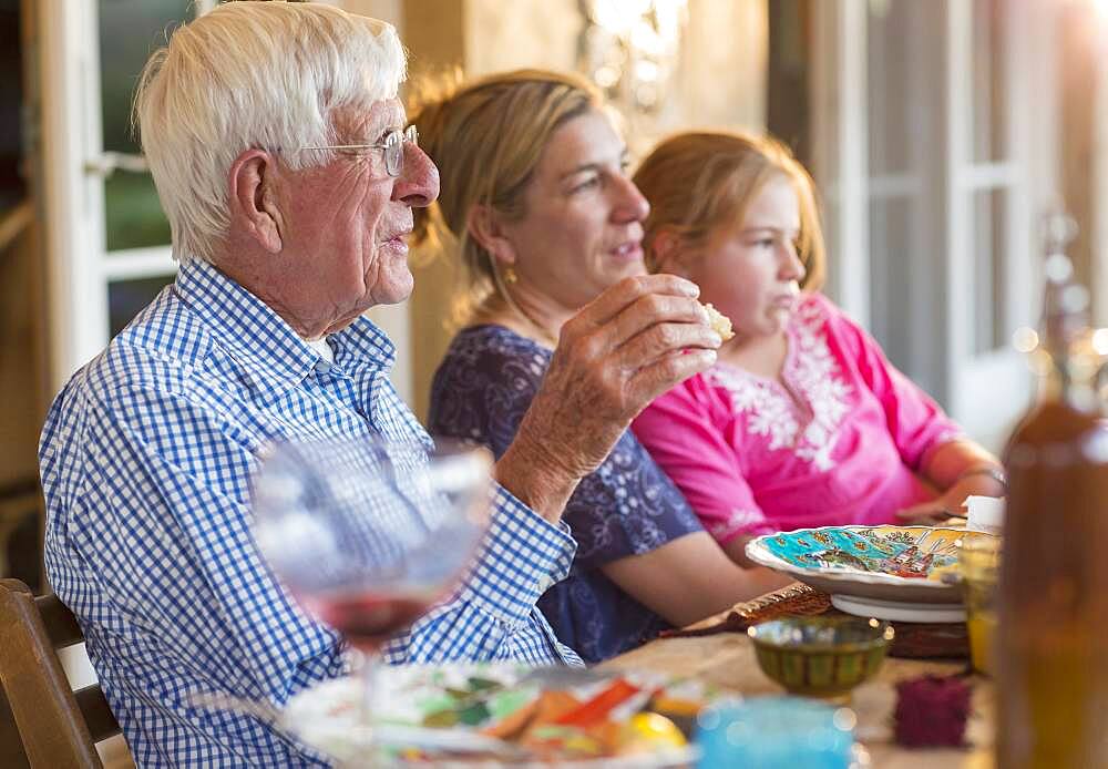 Caucasian family eating at table outdoors