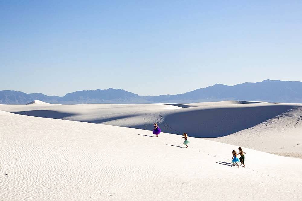 Girls walking on desert sand dunes