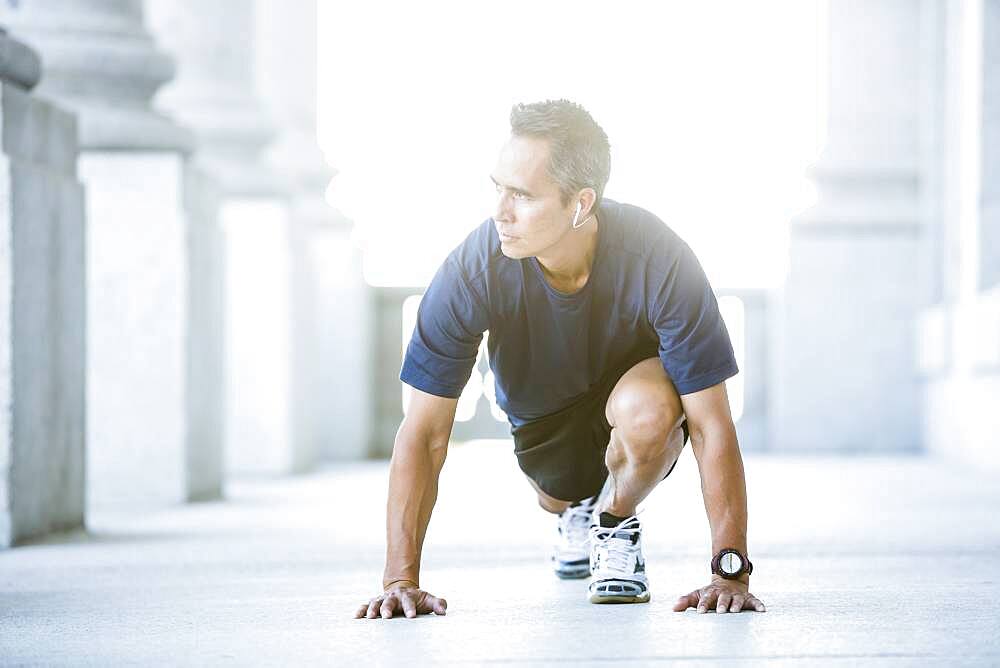 Mixed race man stretching outside courthouse