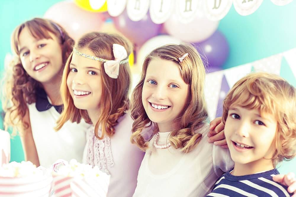 Smiling children hugging at birthday party