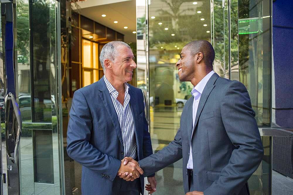 Businessmen shaking hands at office building