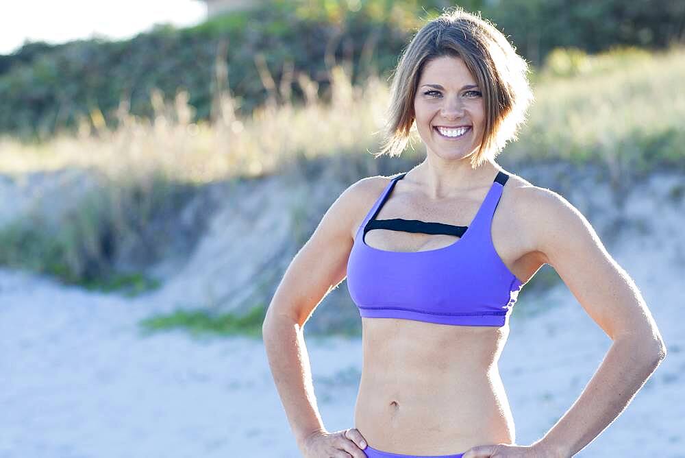 Caucasian woman wearing sports bra on beach