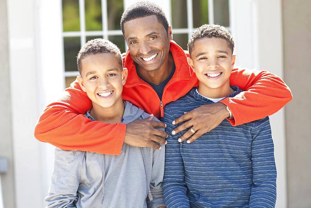 Father hugging sons outdoors