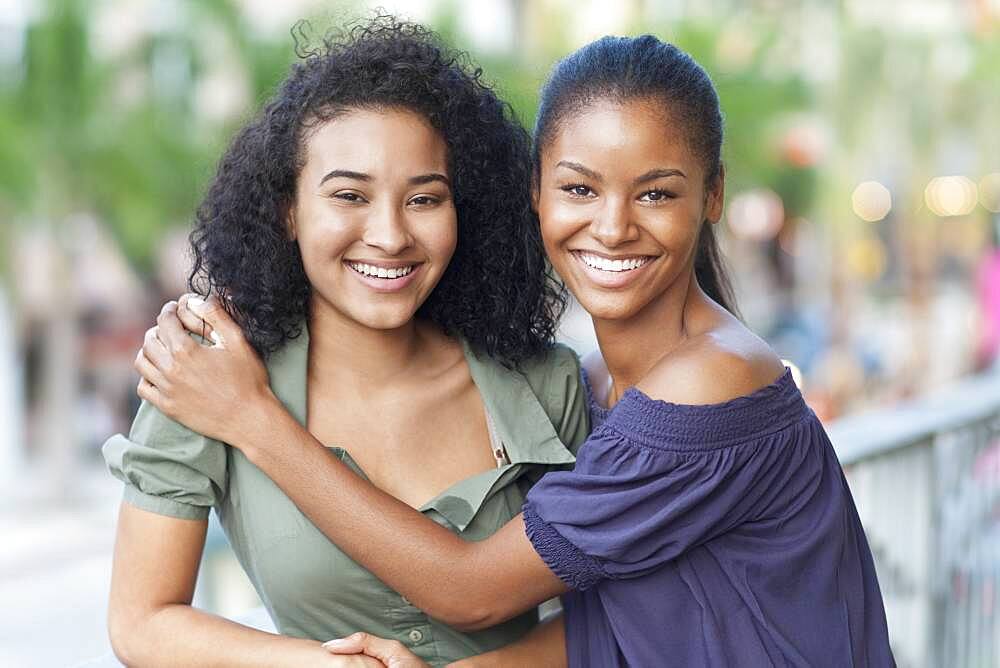 Black women hugging on balcony