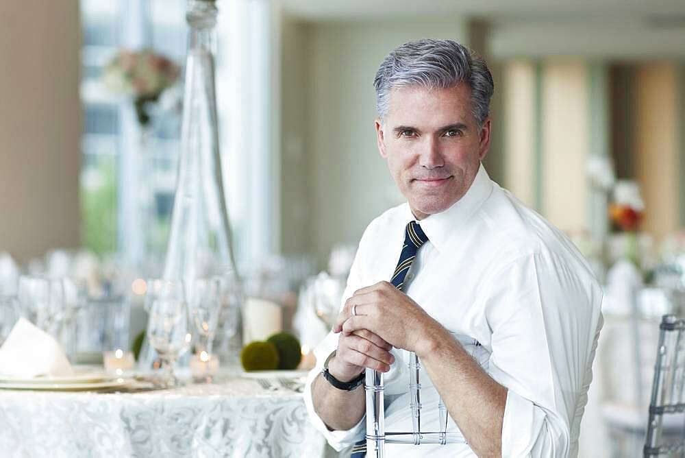 Caucasian businessman smiling in empty dining room