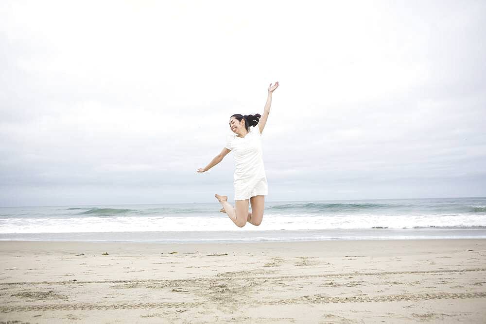 Woman jumping for joy on beach