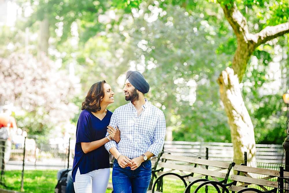 Indian couple walking in urban park