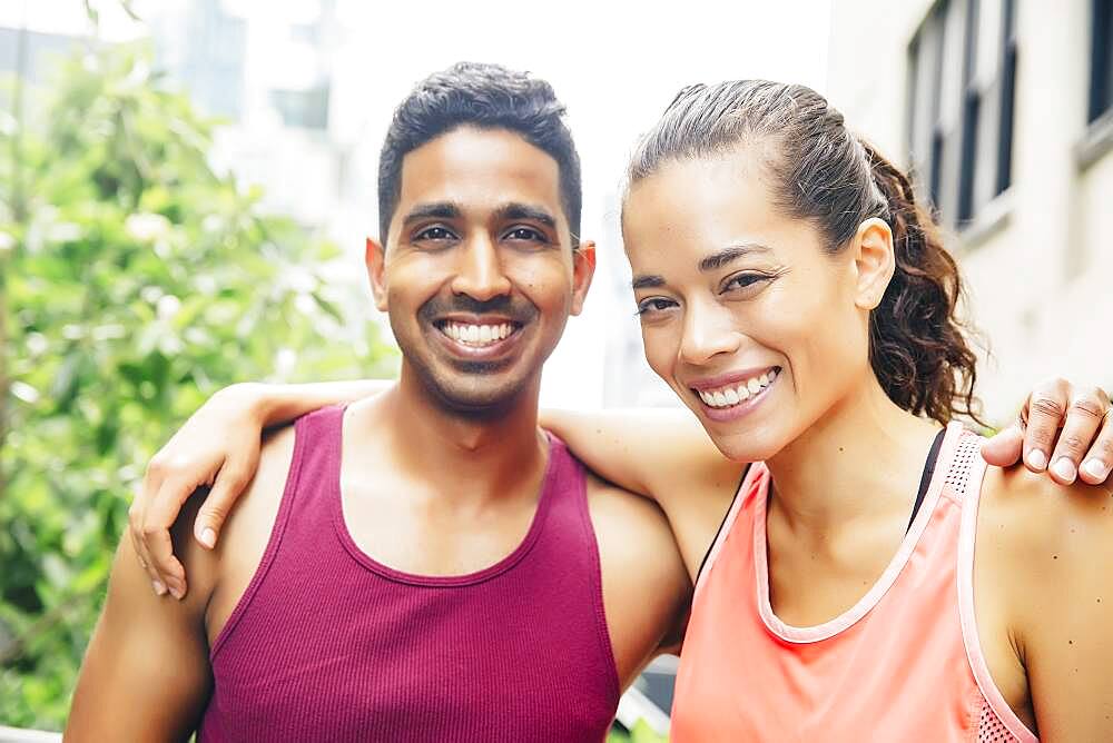 Smiling couple hugging on urban rooftop