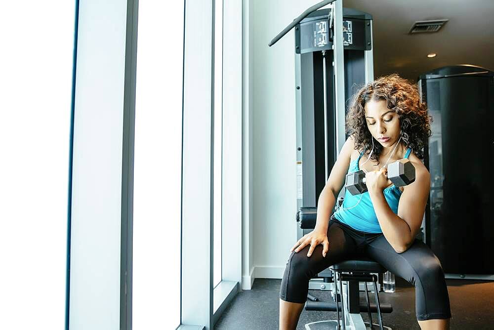 Woman lifting weights in gymnasium