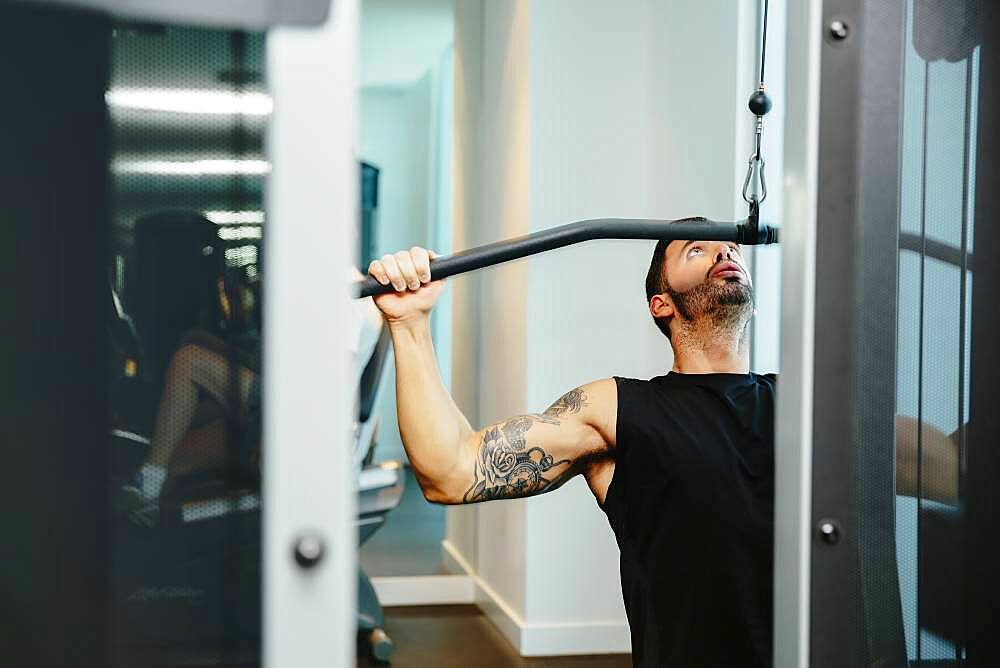 Man using exercise machine in gymnasium