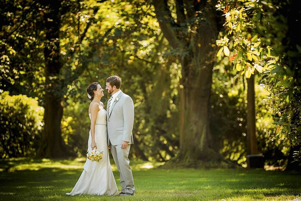 Caucasian bride and groom walking in grass