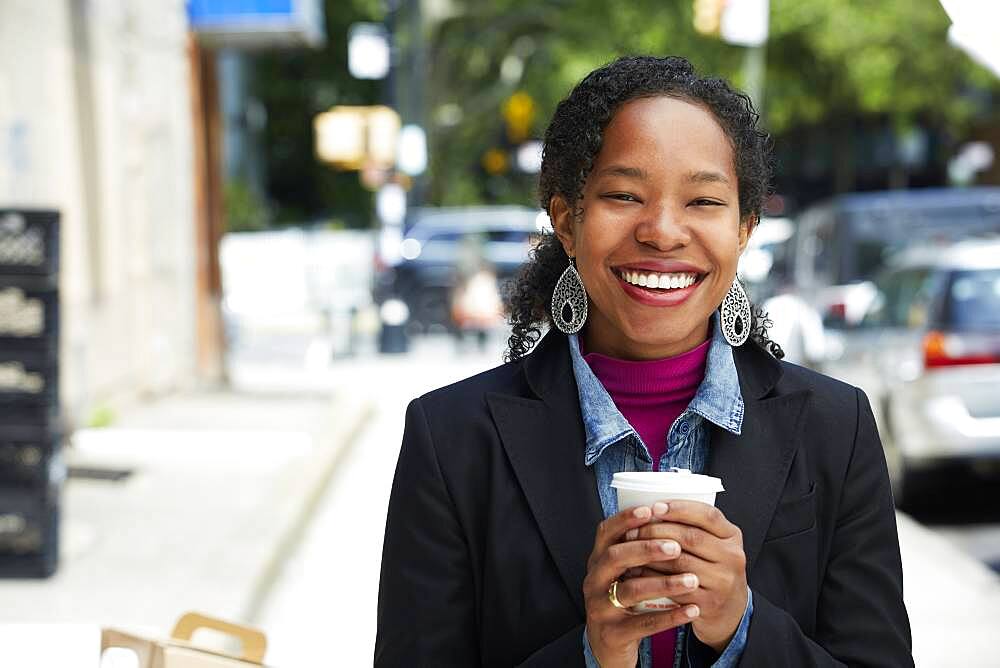 Black woman drinking coffee outdoors