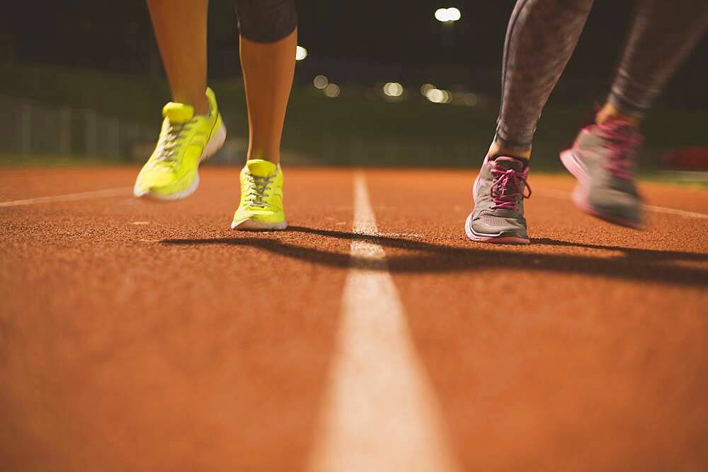 Athletes running on track on sports field