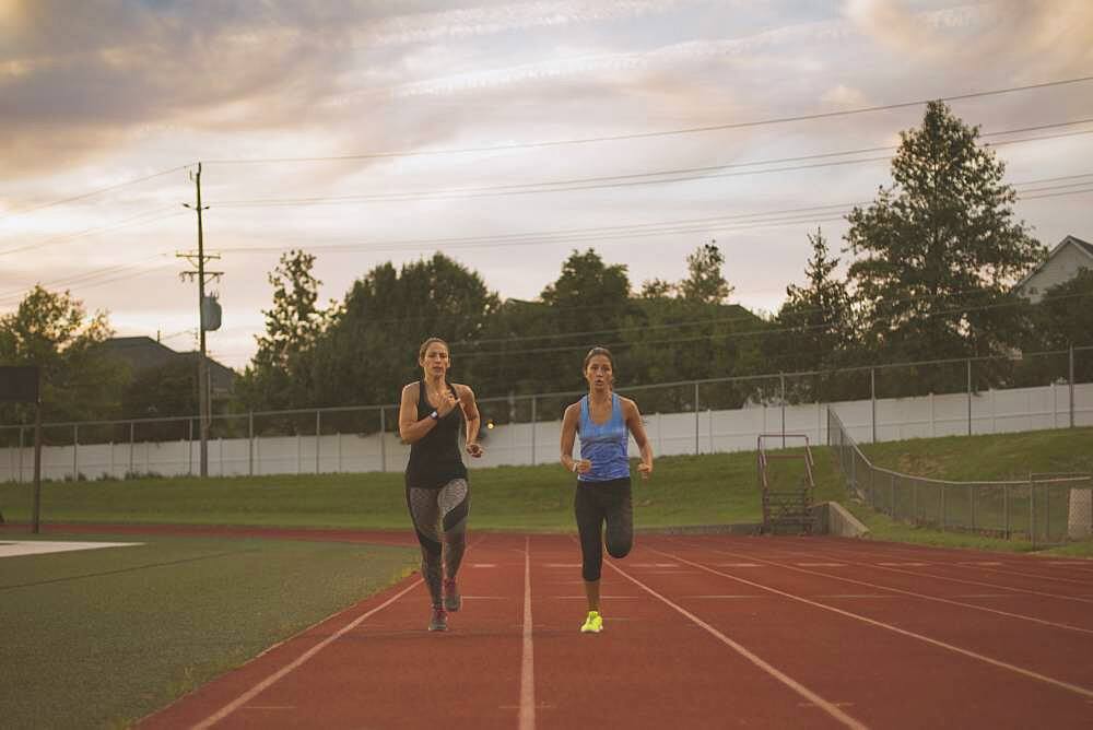 Athletes running on track in sports field