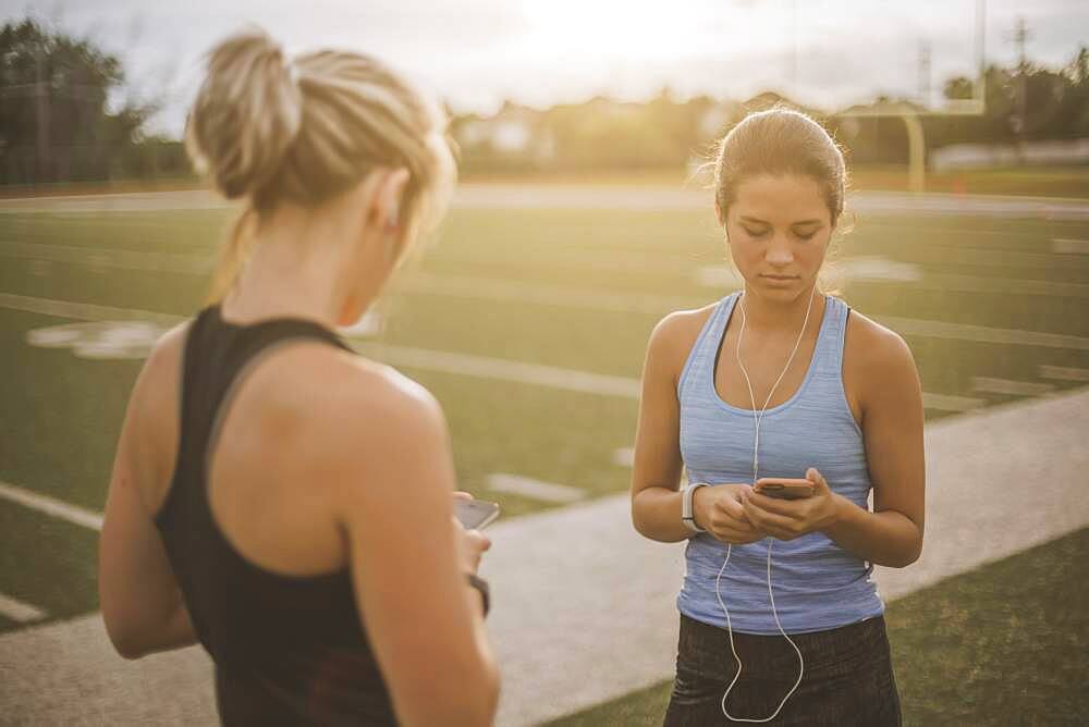 Athletes listening to mp3 players on sports field